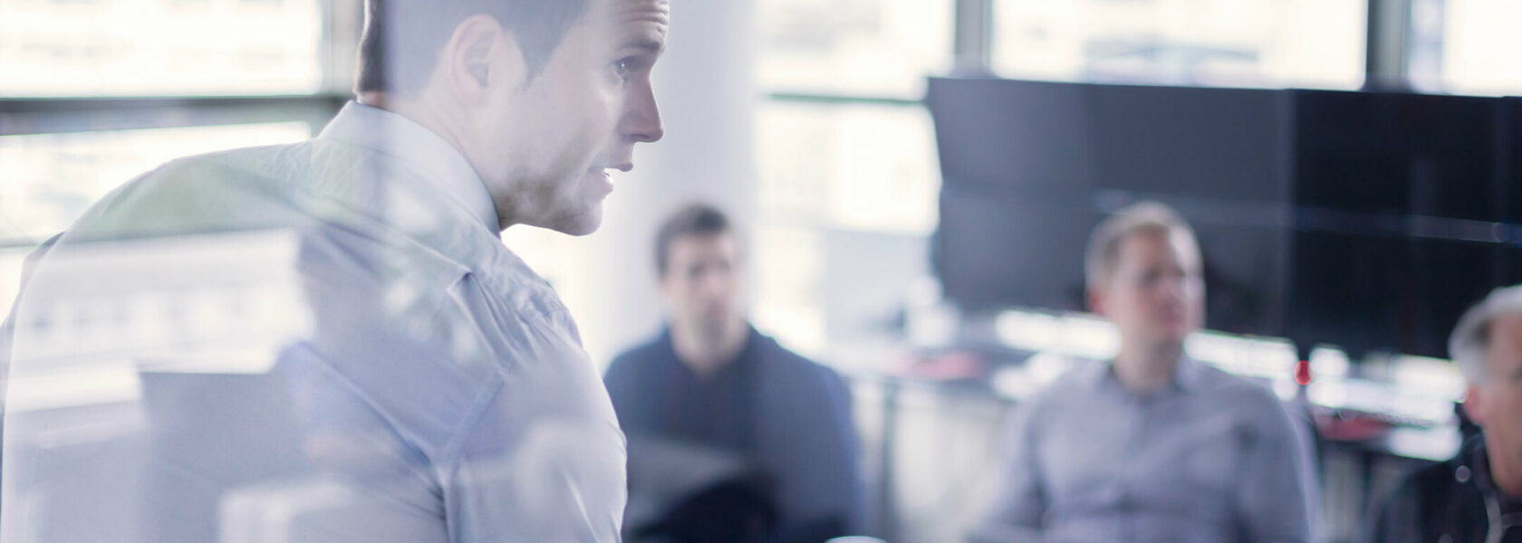 Un formateur debout s’adressant à un groupe de personnes devant une présentation